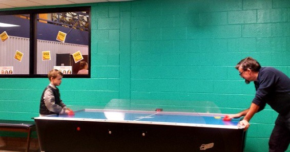 Mark and C-Dog playing air hockey at the YMCA before swim practice